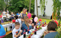 Powiększ zdjęcie: Dzieci jedzą przy stole. 