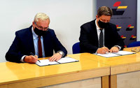Powiększ zdjęcie: Janusz Malinowski i Grzegorz Schreiber siedząc przy stole podpisują dokumenty.