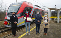 Powiększ zdjęcie: Rekordowy Pasażer na tle pociągu z przedstawicielami władz regionu i spółki