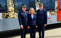 Powiększ zdjęcie: Córka generała Andersa i Prezesi ŁKA stoją na tle pociągu.