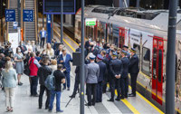 Powiększ zdjęcie: Zdjęcie przedstawiające zebranych gości oraz dziennikarzy, słuchających przemowy przed pociągiem ŁKA Anders