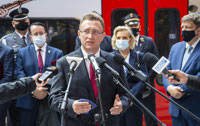 Powiększ zdjęcie: Dyrektor Dariusz Rogu przemawia na tle pociągu ŁKA Anders, za nim stoją zaproszeni goście