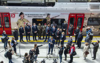 Powiększ zdjęcie: Zdjęcie wykonane z góry, przedstawia przemawiającego Marszałka Województwa Łódzkiego Grzegorza Schreibera oraz zaproszonych gości, stojących obok pociągu ŁKA Anders