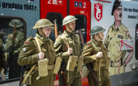 Powiększ zdjęcie: Zdjęcie przedstawia osoby w strojach żołnierzy armii generała Andersa z czasów walk drugiej wojny światowej. 