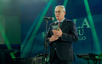 Powiększ zdjęcie: Prezes Janusz Malinowski przemawia na scenie, w rękach trzyma nagrodę. 