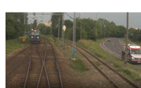 Powiększ zdjęcie: Zapis z monitoringu akcji - ludzie widoczni na torach.Z naprzeciwka nadjezdza pociąg towarowy.