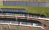 Powiększ zdjęcie: Widok z góry na panele na zapleczu, obok torowisko z pociągami ŁKA.