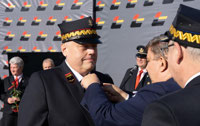 Powiększ zdjęcie: Marszałek WŁ Grzegorz Schreiber przypina do piersi odznakę "Zasłużony dla kolejnictwa" uhonorowanej osobie.