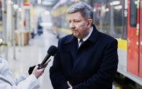 Powiększ zdjęcie: Marszałek udziela wywiadu, w tle hala serwisowa ŁKA. 