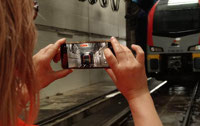 Powiększ zdjęcie: Uczestniczka robi zdjęcie telefonem pociągu ŁKA podczas mycia na myjni. 