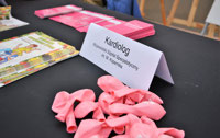 Powiększ zdjęcie: Różowe balony, wizytówka kardiologa przy stoliku 